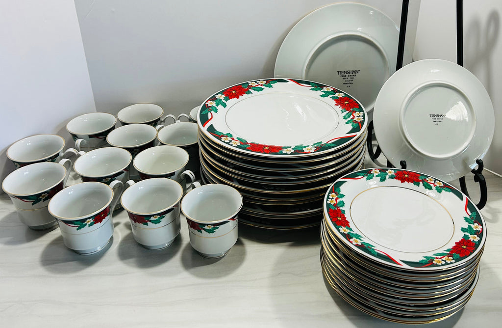 Set of ceramic plates and cups with floral design on a white surface.